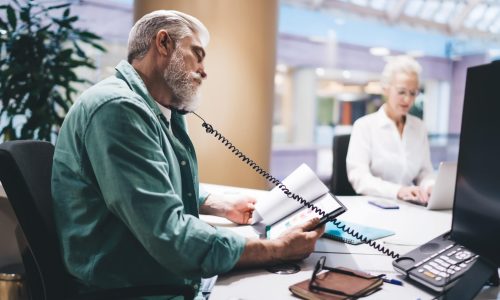 focused-senior-caucasian-man-multitasking-with-pho-2025-03-25-05-08-40-utc-min